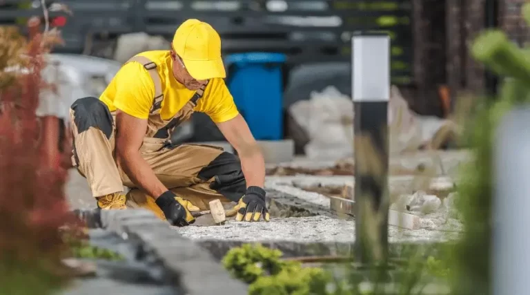 landscaper flattening gravel on garden path